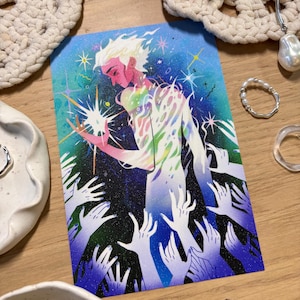 Puede incluir: L&aacute;mina art&iacute;stica que representa una figura celestial con cabello blanco y un aura colorida, sosteniendo una estrella brillante. La ilustraci&oacute;n tiene un fondo azul y morado con manos extendidas.