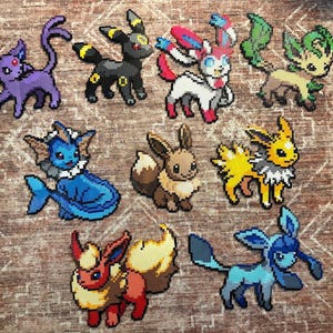 Könnte beinhalten: Eine Sammlung farbenfroher Pixelkunstfiguren, darunter eine lila katzenartige Kreatur, eine schwarze kaninchenartige Figur und mehrere andere tierähnliche Charaktere in verschiedenen Farben. Die Figuren sind auf einer strukturierten, braunen Oberfläche angeordnet.
