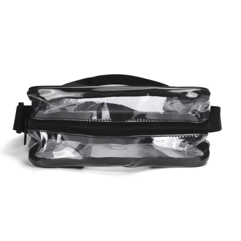 May include: A clear rectangular waist bag featuring black trim and a black zipper closure. The bag includes an adjustable black strap attached to the sides, providing a transparent view of the interior compartment through the plastic material.