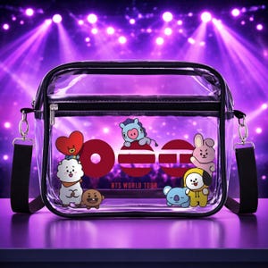 Könnte beinhalten: Transparente Umhängetasche mit schwarzem Rand und Riemen, verziert mit Cartoon-Charakteren. Die Tasche hat einen Reißverschluss und den Text "BTS WORLD TOUR" in Rot. Der Hintergrund ist eine lila Bühne mit Scheinwerfern.