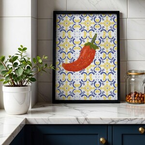 Könnte beinhalten: Gerahmter Kunstdruck mit einer leuchtend roten Chili-Pfeffer-Illustration. Der Hintergrund zeigt ein Muster aus blauen und gelben Blumenmotiven. Das Kunstwerk ist in einem schwarzen Rahmen präsentiert, ideal für Küchen- oder Esszimmerdekoration.