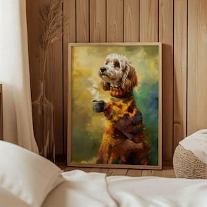 Op de afbeelding: Een ingelijste kunstdruk van een hond met een trui met patroon en een mok, waar stoom uit komt. De hond heeft lichtbruine vacht en staat tegen een kleurrijke, schilderachtige achtergrond. Het kunstwerk zit in een houten lijst.
