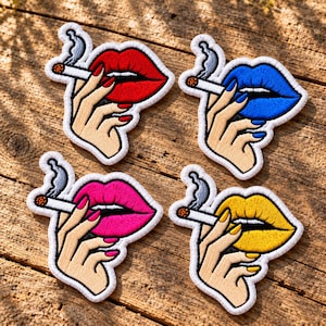 May include: Four embroidered patches featuring a hand holding a lit cigarette near a pair of lips. The lips are colored red, blue, pink, and yellow, with matching nail polish on the fingers. Each patch has a white border and a gray smoke plume.
