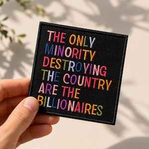 May include: A square black embroidered patch featuring the multi-colored text THE ONLY MINORITY DESTROYING THE COUNTRY ARE THE BILLIONAIRES. The letters are stitched in various vibrant colors including pink, blue, yellow, and purple against a black background.