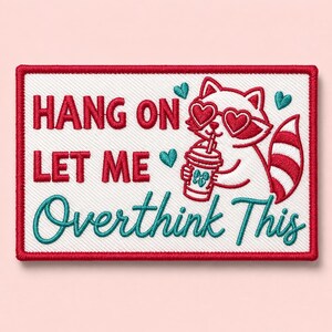 May include: A rectangular embroidered patch with a white background and a red border. It features a white raccoon wearing heart-shaped glasses, holding a drink, and the red and teal text: HANG ON LET ME Overthink This, with small teal hearts.