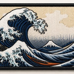 May include: A rectangular embroidered patch featuring a detailed depiction of a large crashing wave in shades of deep blue and white, with a snow-capped mountain peak visible in the background and a small orange boat nestled within the turbulent water.
