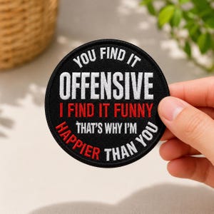 May include: A circular black embroidered patch featuring white and red text that reads: YOU FIND IT OFFENSIVE, I FIND IT FUNNY, THAT'S WHY I'M HAPPIER THAN YOU. The patch has a stitched border and is designed for application to fabric items.