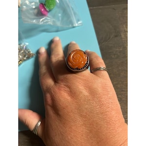 May include: A white ceramic mug with a black handle and the text "But First, Coffee" in a handwritten style. The mug is on a white surface. The mug is approximately 4 inches tall.