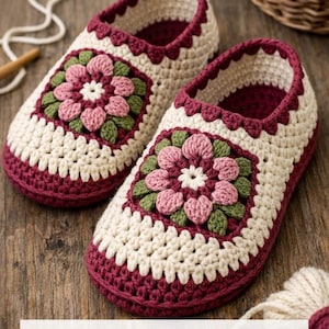 May include: A pair of handmade crochet slippers with a floral design. The slippers are cream-colored with burgundy trim and a square floral applique in pink and green. The text "Crochet Slipper Pattern" is at the bottom.