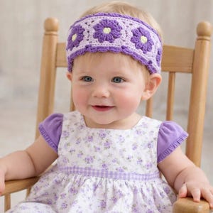 May include: A crochet headband featuring a repeating pattern of purple flowers with yellow centers on a light purple background. The headband has a scalloped edge and is worn with a white dress with a purple floral print and purple sleeves.