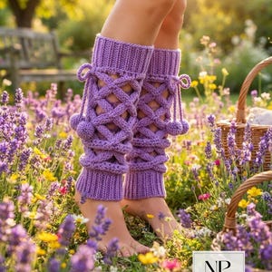 May include: A pair of lavender-colored crochet leg warmers featuring a lattice-style cable knit pattern, ribbed cuffs at the top and bottom, and decorative side ties with matching yarn pom-poms. The text NP NEATPRINTABLE is visible.