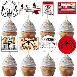 May include: Nine cupcakes with white frosting and colourful sprinkles. The cupcakes are decorated with themed toppers, including a cassette tape, a sign saying "Welcome to Hawkins", and a Demogorgon illustration.