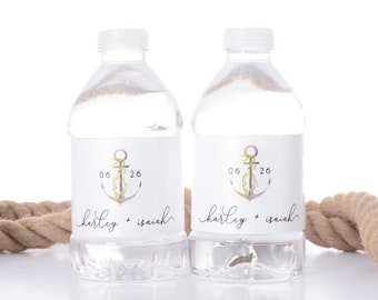 May include: Two clear plastic water bottles with white labels. The labels feature a watercolor anchor with greenery and the text "06 26 harley + isaiah".
