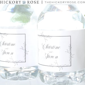 May include: Two clear plastic water bottles with white labels. The labels have a black border and a delicate floral design. The text on the labels reads "Christine and Steven".