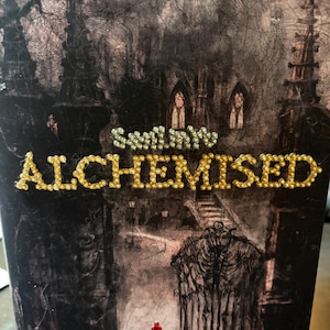 May include: A gothic-themed illustration with the word "ALCHEMISED" in gold and silver lettering. The image shows a detailed depiction of a castle, a gate, and a small cluster of red objects.