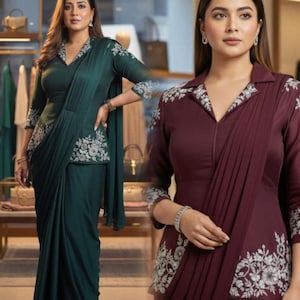 Puede incluir: Dos mujeres con elegantes saris, verde oscuro y burdeos. Los saris presentan una parte superior con cuello y bordados florales en el cuello y las mangas. La tela drapeada crea un look sofisticado y formal, adecuado para ocasiones especiales.