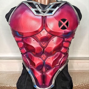 Puede incluir: Una armadura de pecho roja y morada con un ribete plateado y el logotipo de X-Men. La armadura está diseñada para parecerse a un físico musculoso, con paneles y sombreados detallados. La pieza del pecho se exhibe en un maniquí.