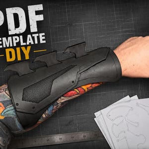 May include: A black forearm gauntlet featuring three distinct fin-like protrusions and a textured mesh panel. The text PDF TEMPLATE DIY is displayed in the upper left corner. The gauntlet is worn on an arm, with paper templates visible below.