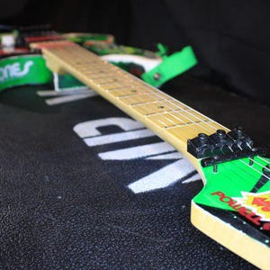 May include: A white ceramic mug with a black handle and the text "But First, Coffee" in a bold, black font. The mug is set against a blurred background, suggesting a cosy setting.