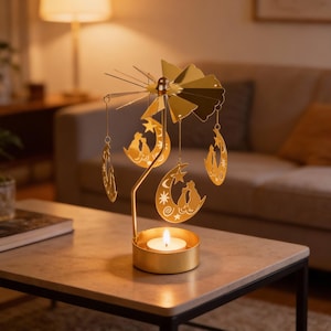 Może przedstawiać: Złoty świecznik z obrotowym wzorem. Uchwyt ma okrągłą podstawę ze świecą, która podtrzymuje konstrukcję z wiszącymi ozdobami w kształcie księżyca i gwiazdy. Ozdoby przedstawiają sylwetki par. Odpowiedni do dekoracji wnętrz.