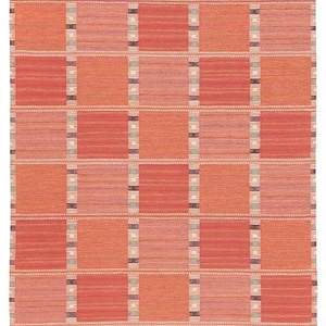 May include: A rectangular woven rug with a geometric pattern. The rug features a grid of alternating rectangular blocks in shades of orange, red, and pink. Vertical stripes with small accents of blue and purple separate the blocks.