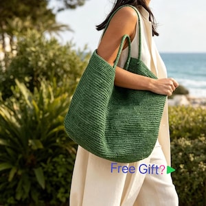 Può includere: Una grande borsa tote intrecciata verde scuro con due tracolle. La borsa presenta una struttura in materiale testurizzato simile alla paglia con un design spazioso a apertura superiore. La superficie ha un motivo a coste orizzontali uniforme.