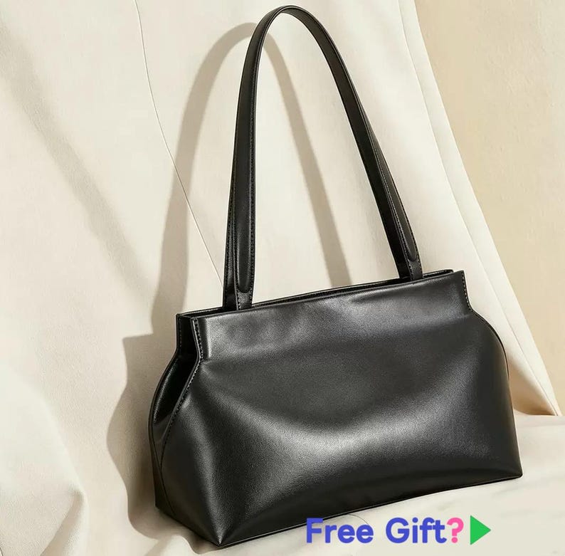 May include: A black handbag with two long handles. The bag has a rectangular shape with rounded corners and a smooth, shiny surface. The handles are thin and attached to the top of the bag. The bag is set against a neutral background.