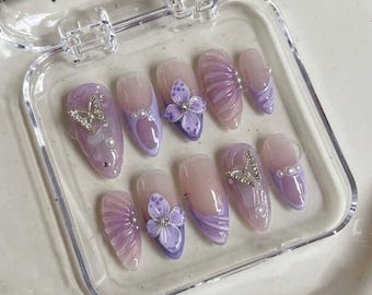 Uñas postizas con diseño de mariposa lavanda: flores en 3D, mármol y perlas francesas.