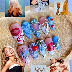 May include: A collection of nail art designs featuring various styles and embellishments. Designs include lip prints, hearts, bows, and intricate patterns. The nails are in shades of pink, blue, and white, with gold accents and rhinestones.
