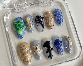 Uñas postizas hechas a mano con motivos marinos, tortugas marinas, pulpos y tiburones, con detalles de conchas de perlas costeras.