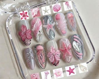 Uñas postizas rosas hechas a mano con motivos de océano, conchas marinas, hibisco y estrellas de mar.
