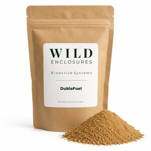 May include: A brown paper pouch with a white label featuring the text WILD ENCLOSURES, Bioactive Systems, DubiaFuel, and WildEnclosures.Com. A pile of fine, light brown powder sits in front of the pouch on a plain white background.