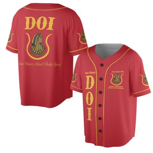 Könnte beinhalten: Rotes Baseball-Trikot mit goldfarbenen Zierleisten und schwarzen Knöpfen. Das Trikot zeigt den Text "DOI" in Gold auf der Vorder- und Rückseite, zusammen mit einer Illustration und dem Text "Four Women Mind Body Spirit". Es hat auch den Text "Oasis of Memphis Desert of Tennessee".
