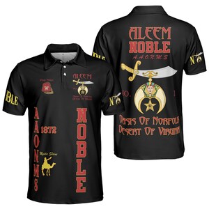 May include: Black polo shirt with red and gold graphics. The shirt features the text "ALEEM NOBLE A.A.O.N.M.S" and other text and symbols. The back of the shirt has a large graphic with a sword and crescent moon.