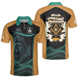 Peut inclure: Un polo à manches courtes avec un motif maçonnique. Le t-shirt présente un corps beige avec des accents noirs et turquoise. L'avant affiche des symboles maçonniques, tandis que le dos porte un blason et la phrase latine "JUNXIT MORS NON SEPARABIT".