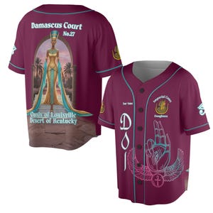 Könnte beinhalten: Burgunderfarbenes Baseball-Trikot mit türkisfarbenen Akzenten. Auf der Rückseite befindet sich eine Illustration einer Frau in goldenen und türkisfarbenen Gewändern mit dem Text "Damascus Court No.27" und "Oasis of Louisville Desert of Kentucky". Auf der Vorderseite steht "Imperial Court Daughters".