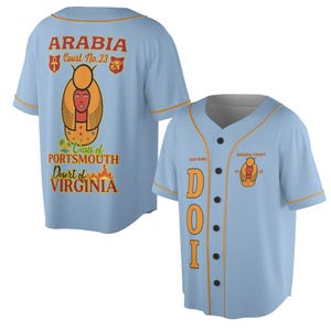 Könnte beinhalten: Hellblaues Baseball-Trikot mit orangefarbenen Zierleisten und schwarzen Knöpfen. Auf der Rückseite steht "ARABIA Court No. 23" und eine ägyptisch anmutende Grafik. Auf der Vorderseite stehen die Buchstaben "DOI" und "ARABIA COURT".