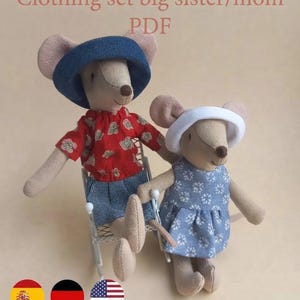 Op de afbeelding: Twee beige stoffen muispoppen. De grotere muis draagt een blauwe hoed, een rood bloemig shirt en een blauwe broek, zittend op een witte stoel. De kleinere muis draagt een witte hoed en een blauwe bloemige jurk. Tekst: Clothing set big sister/mom PDF.