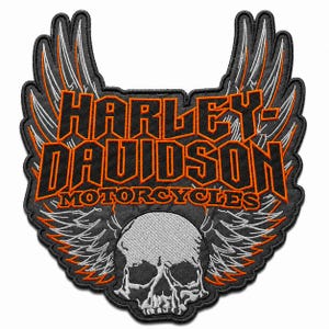 May include: An embroidered patch featuring the text HARLEY-DAVIDSON MOTORCYCLES in orange and black lettering. The design includes a detailed grey and white skull at the bottom, flanked by large, stylized wings with orange and grey stitching.
