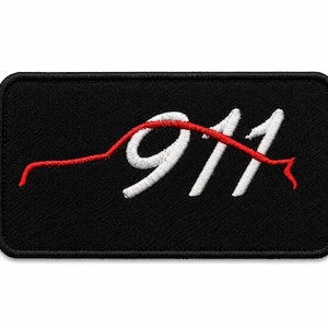 May include: A rectangular black embroidered patch featuring a white stitched number 911. A thin red embroidered line traces the silhouette of a sports car profile, curving over the top of the numbers and extending across the black fabric background.