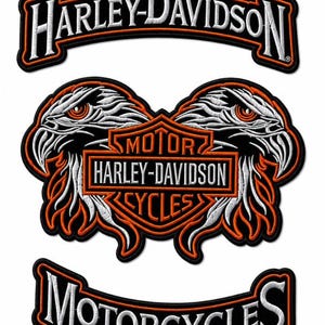 May include: A set of three embroidered patches featuring the Harley-Davidson logo. The top patch reads Harley-Davidson in white text. The center patch displays two eagle heads flanking a motor cycles shield logo. The bottom patch reads Motorcycles.
