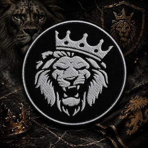 May include: Black circular patch featuring a detailed white embroidered lion's head wearing a crown. The lion is roaring, with its teeth bared. The patch has a white border and is set against a dark, textured background with additional lion imagery.