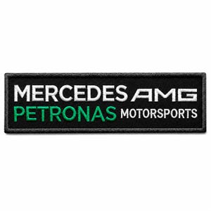 May include: A rectangular embroidered patch with a black background. The text MERCEDES AMG is stitched in white, while the word PETRONAS is in bright green, followed by the word MOTORSPORTS in white. The patch features a black stitched border.