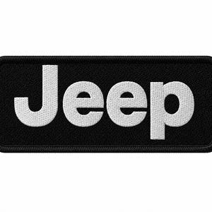 May include: Black rectangular patch with the white embroidered word "Jeep". The patch has a black border and the letters are in a bold, sans-serif font. The patch is likely for clothing or accessories.