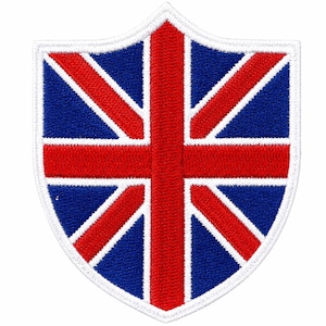 Puede incluir: Un parche en forma de escudo con la Union Jack, la bandera nacional del Reino Unido. El diseño incluye un fondo azul con una cruz roja y rayas diagonales, todo delineado en blanco.