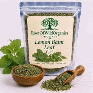 May include: A clear, sealed bag of dried lemon balm leaf cut, with a label that reads "Root of Wild Organics." A wooden bowl and scoop hold the dried herb, with fresh lemon balm leaves in the background. The label also says "Organic, Wild-Harvested, Nutrient-Rich."