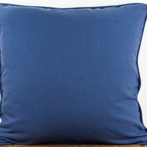 May include: A solid blue throw pillow with a simple design. The pillow is made of a soft, textured fabric.
