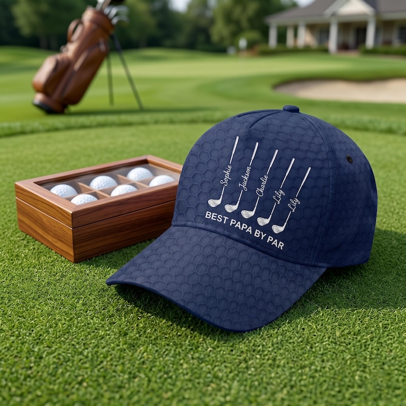 May include: A navy blue baseball cap with a textured honeycomb pattern. The front features five white golf club graphics, each labeled with the names Sophie, Jackson, Charlie, Lily, and Lily, followed by the white text BEST PAPA BY PAR.