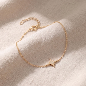 May include: A white ceramic mug with a black handle and the text "But First, Coffee" in a black, handwritten-style font. The mug is on a white surface.