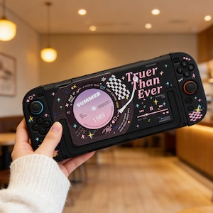 Op de afbeelding: Zwarte gameconsole-hoes met een retro vinylplaatontwerp. De hoes heeft de tekst "Truer Than Ever" en "Summer 1989". De hoes heeft kleurrijke knoppen en accenten, met een geblokte vlag en sterren.